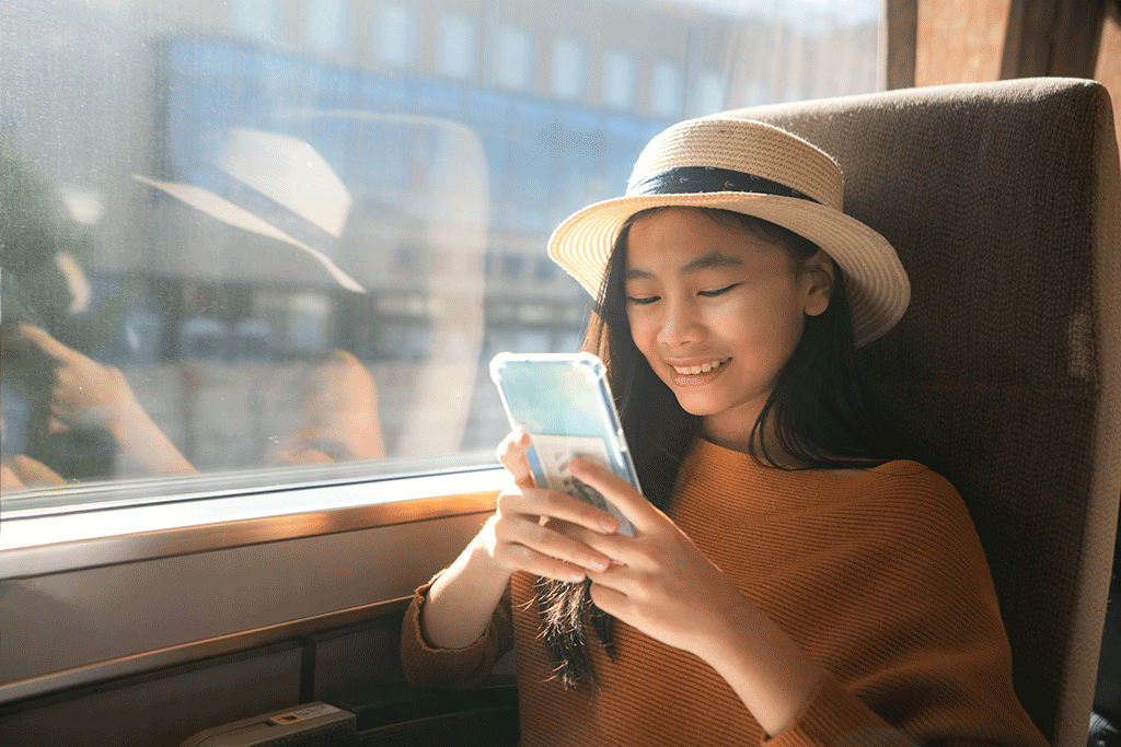 Une personne voyageant dans un train regarde un smartphone.