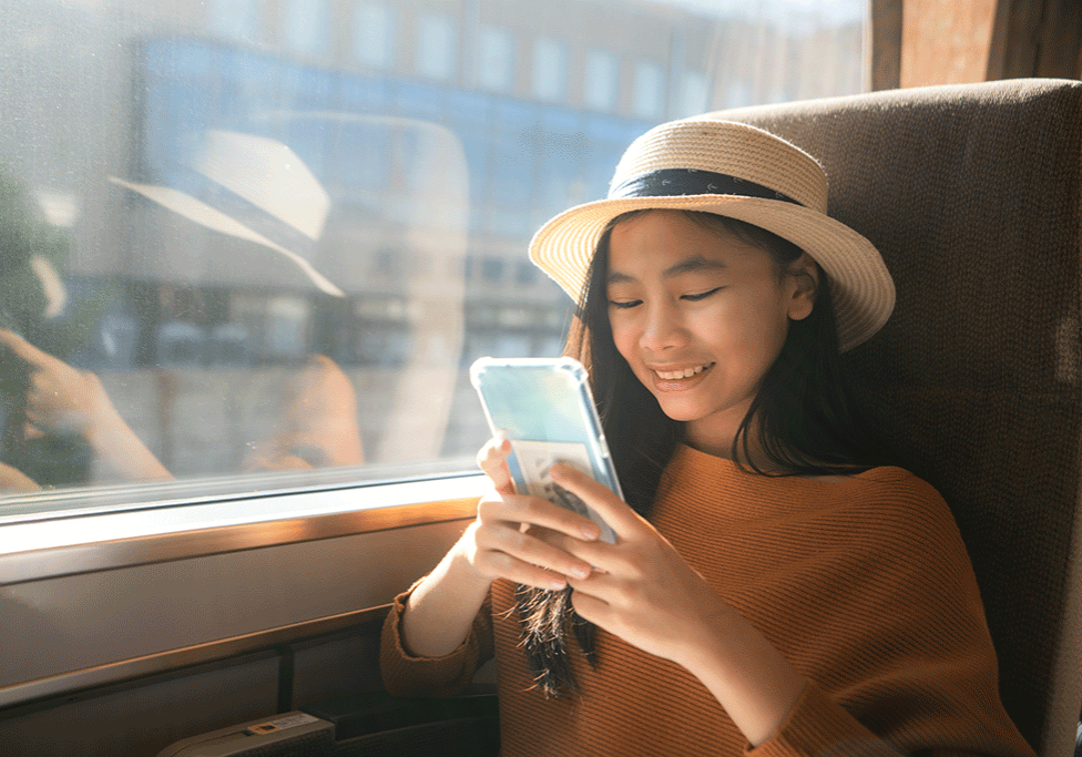 Une personne voyageant dans un train regarde un smartphone.