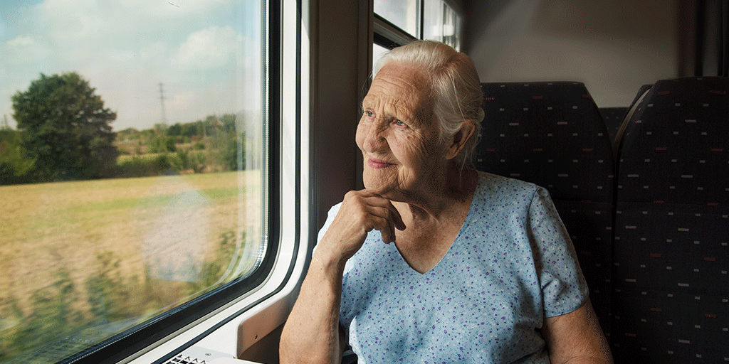 Une personne regarde par la fenêtre alors qu'elle voyage en train.