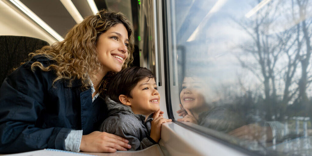 Vue en angle bas des passagers du train regardant par la fenêtre le paysage qui passe.